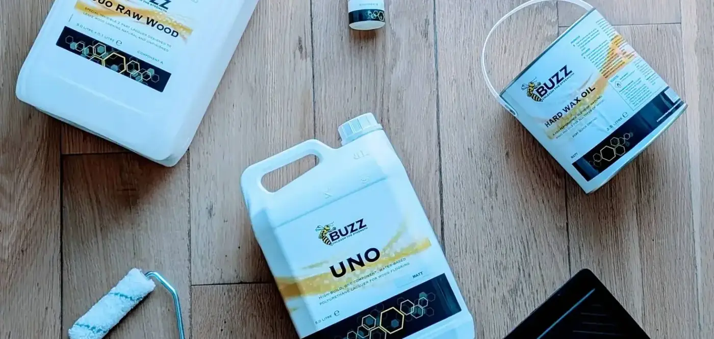 Buzz-branded flooring finish products on a wood floor