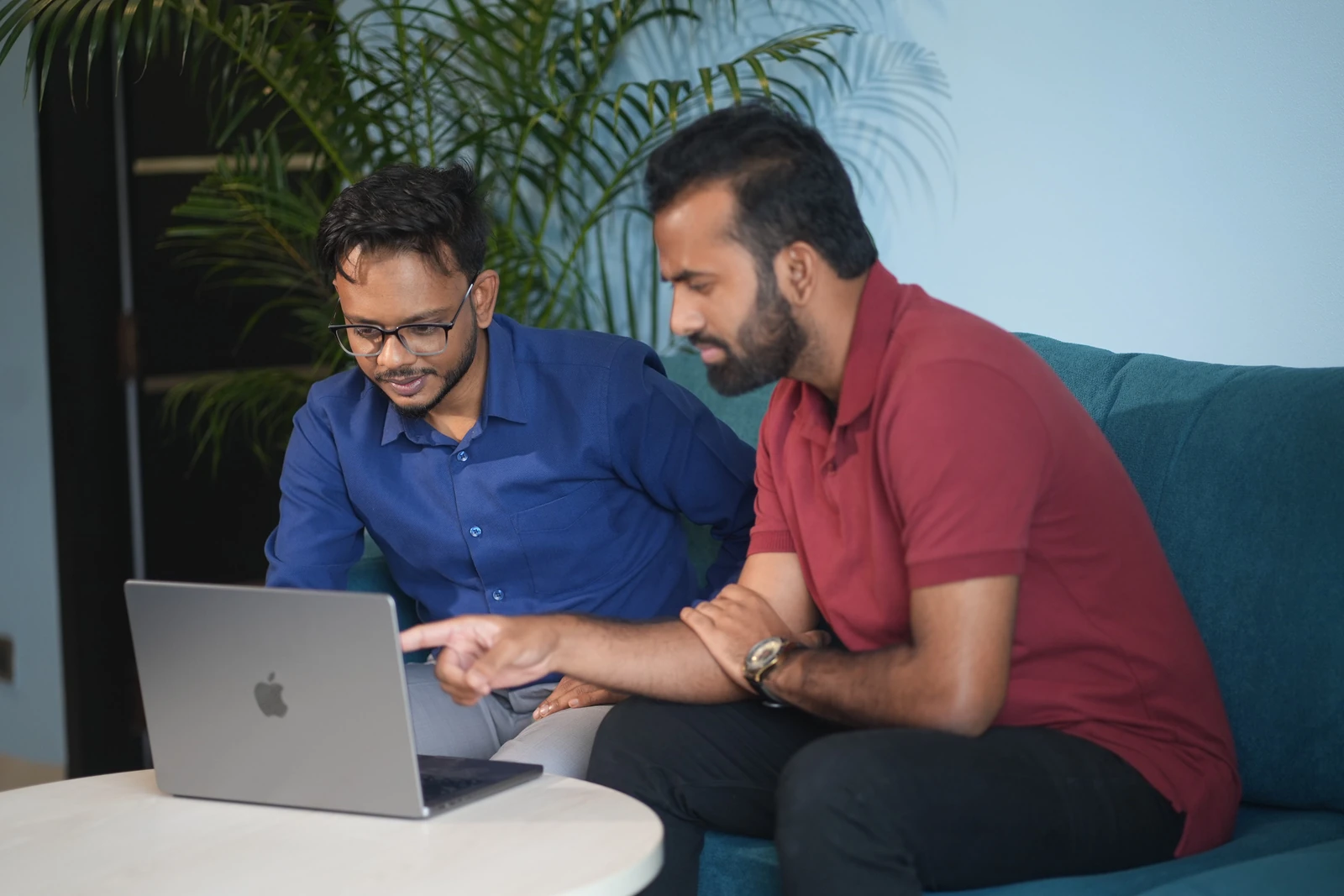 Two colleagues discussing work on a laptop in our office